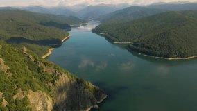 Aerial footage of Vidraru lake, in Romania. Video was shot from a drone from above  the dam at Vidraru lake with the camera level and flying forward for a top view of lake for a panoramic shot.