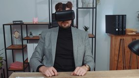 Businessman in suit working using virtual reality futuristic technology VR app headset helmet at home office. Freelancer man busy creating new architecture project. Remote education, study, learning