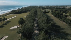 Drone view of highway between the pine trees and near the beachside golf course