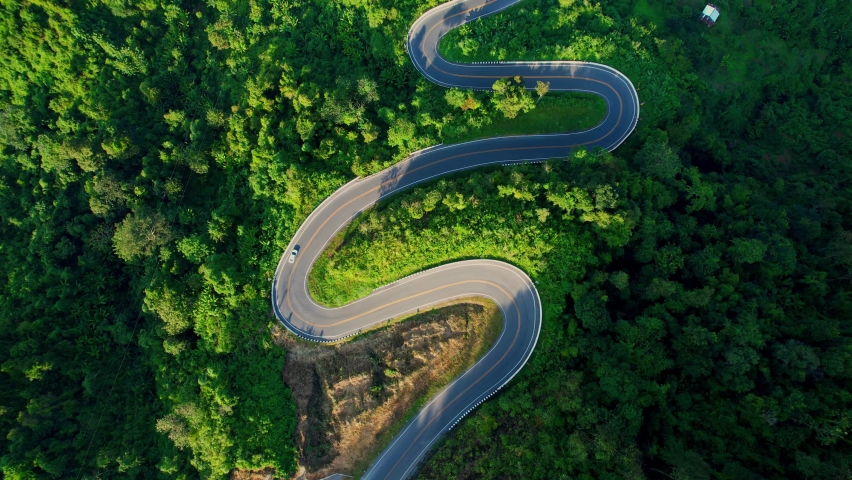 Drone flying above winding road during sunlight, Winding asphalt road through tropical rainforest. amazing zigzag road. countryside landscape. Landmark tourist attractions in Nan Province, Thailand
 Royalty-Free Stock Footage #1096612823