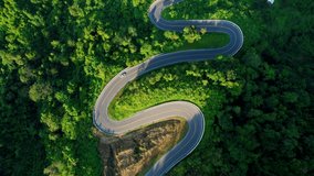 Drone flying above winding road during sunlight, Winding asphalt road through tropical rainforest. amazing zigzag road. countryside landscape. Landmark tourist attractions in Nan Province, Thailand
 - Powered by Shutterstock - Get 15% off with code: PIKWIZARD15