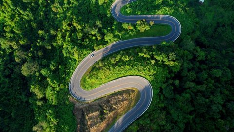 Drone flying above winding road during sunlight, Winding asphalt road through tropical rainforest. amazing zigzag road. countryside landscape. Landmark tourist attractions in Nan Province, Thailand
 स्टॉक वीडियो