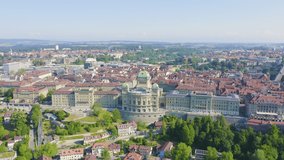 Inscription on video. Bern, Switzerland. Federal Palace - Bundeshaus, Historic city center, general view, Aare river. Shimmers in colors purple, Aerial View