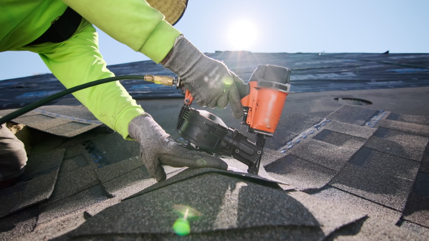 Close up footage of Roofer repair or replace shingle that has been damaged and needing replacement at sunny day.  Royalty-Free Stock Footage #1096613513