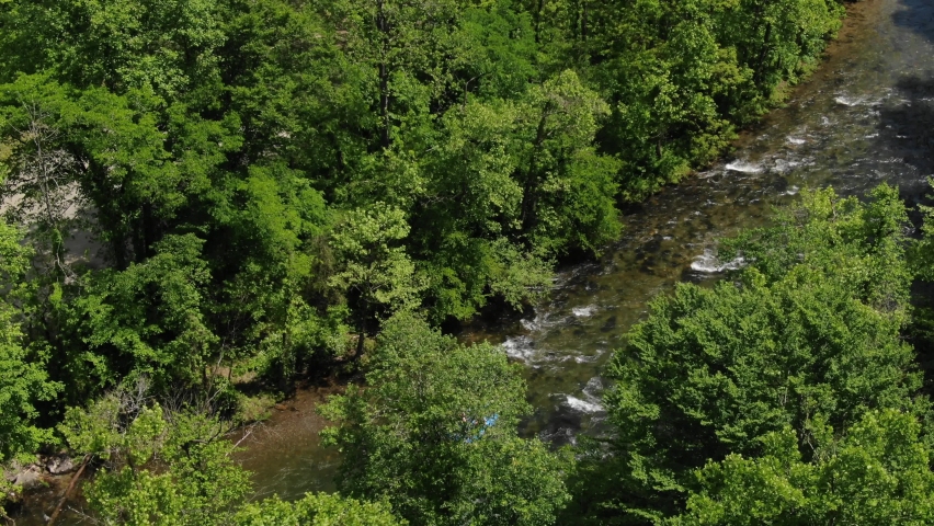 High angle aerial revealing past trees to river rafters in Smoky Mountains North Carolina