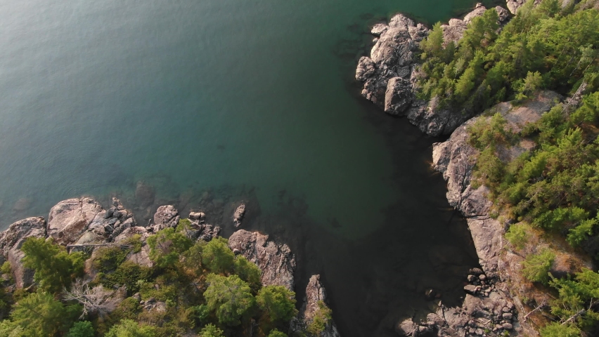 High aerial above calm protected cove on Lake Superior coastline in summer
