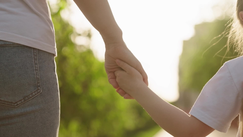 child hand mother close-up. mom holds hand little child kid walking park outdoors. chidhood dream. happy family. hand kid hand parent guardian rays sunlight. city walk child daughter. teamwork. Royalty-Free Stock Footage #1096622163