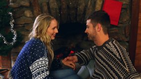 Animation of feliz navidad christmas greetings text over caucasian couple by fireplace at christmas. Christmas, tradition, celebration and festivity concept digitally generated video. - Powered by Shutterstock - Get 15% off with code: PIKWIZARD15