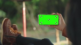 Woman lying at camping tent using smartphone with green screen talking with someone or video call meeting communications concept close up