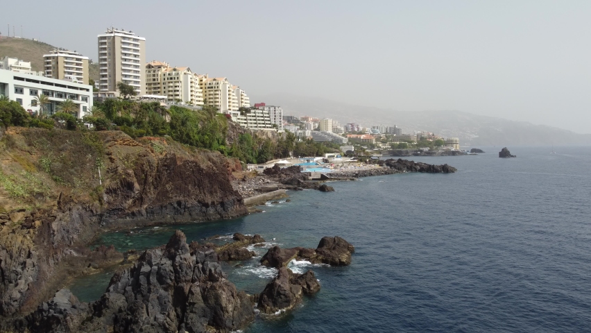 Aerial footage of Madeira cliffs in Funchal with the city in the background