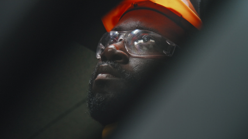 Close up of African American man in hard hat connecting wires while working at industrial factory Royalty-Free Stock Footage #1096650849