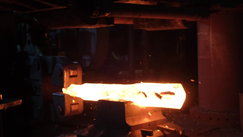 Blacksmith factory. Close-up of robots work. Forging a large hot metal billet with an industrial forging press. Technical equipment of a metal forging plant. Large machines, blacksmiths move and heat Royalty-Free Stock Footage #1096651493