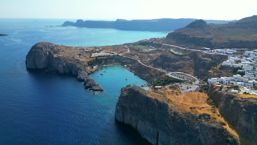 Lindos is a town on the Greek island of Rhodes. It’s known for its clifftop acropolis, which features monumental 4th-century gates and reliefs from about 280 B.C. Royalty-Free Stock Footage #1096661481