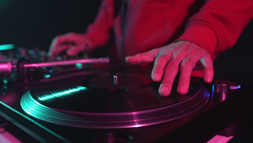 Hip hop dj scratching vinyl record on turntable. Download 4K stock video of disc jockey mixing music on party in night club. Disk jokey scratch records on turntables in nightclub Royalty-Free Stock Footage #1096662769