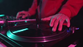Hip hop dj scratching vinyl record on turntable. Download 4K stock video of disc jockey mixing music on party in night club. Disk jokey scratch records on turntables in nightclub