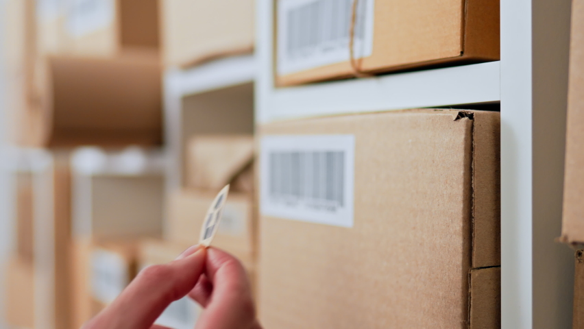 Sticking a recycle sign arrow on a medium-sized business cardboard box, Cardboard box parcel cargo warehouse, an employee marks a shipping box with a recycle sign
 Royalty-Free Stock Footage #1096665387
