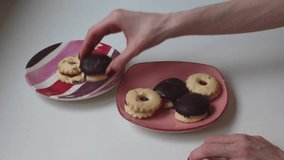 Female hands moving cookies from one plate to another