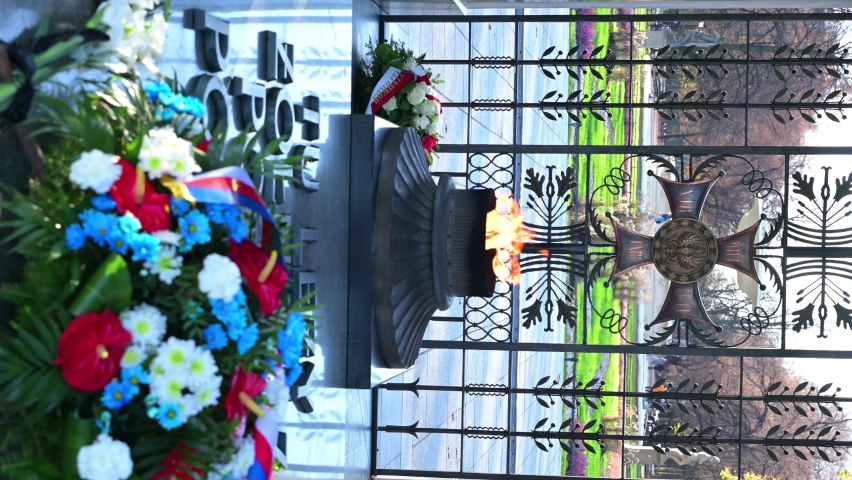 VERTICAL VIDEO, Fire in memory of fallen soldiers, flower wreath, Tomb of the Unknown Soldier in Warsaw