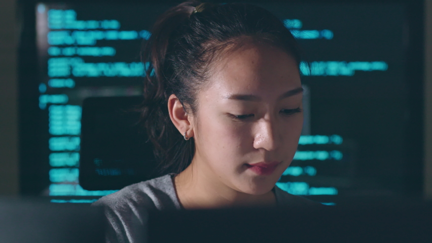 Young Asian woman, developer programmer, software engineer, IT support, working hard at night overtime on computer to check coding in bugging system  Royalty-Free Stock Footage #1096679245