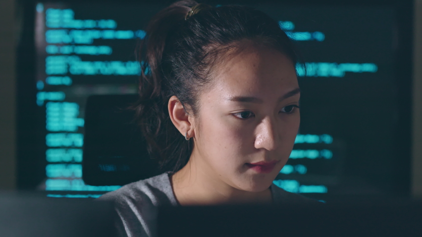 Young Asian woman, developer programmer, software engineer, IT support, working hard at night overtime on computer to check coding in bugging system  Royalty-Free Stock Footage #1096679245