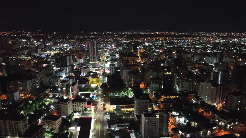 Santo Domingo town center illuminated at night. Aerial orbiting. Sky for copy space