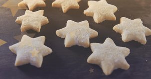 Animation of stars floating over homemade cookies. baking, desserts and christmas concept digitally generated video.