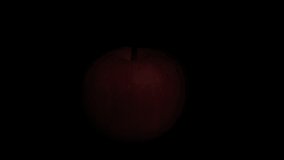 A red apple in water droplets, rotating on a black background, close-up. The apple appears from the shadow into the light. - Powered by Shutterstock - Get 15% off with code: PIKWIZARD15