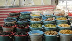 Bunch of fresh olives assortment that is in the bowels in the market. Plates with different types of olives and olives on the market. Mediterranean olive for sale concept. High quality 4k footage