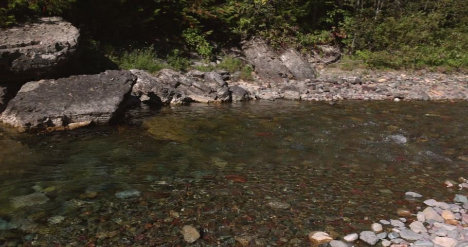 Beautiful glacier river with clear water and colorful rocks in Glacier National Park