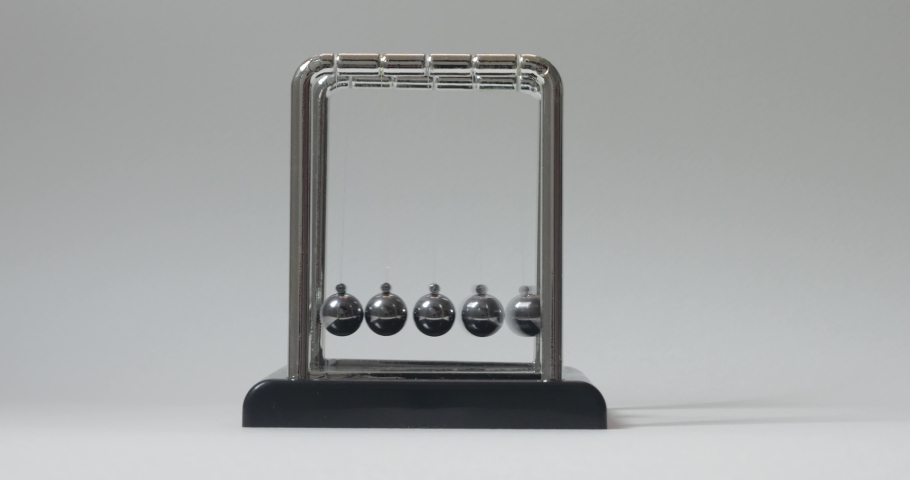 Close-up of driving a simple Newton's cradle. Kinetic pendulum. Chromatic metal balls wobble and slow down. Moving something, inertia concept, science, physics lesson. Psychological hypnosis session Royalty-Free Stock Footage #1096711835