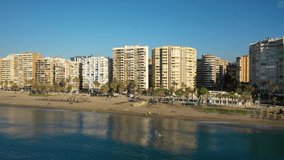 Aerial 4K video from drone to Malagueta ,La Caleta beaches and Malaga city skyline on a beautiful summer at sunrise. Malaga, Andalusia, Costa del Sol of Mediterranean, Europe 
