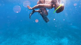 Diver trying to dive deep in turquoise underwater using snorkeling mask, Fins and life jacket | Swimmer or diver diving underwater video background