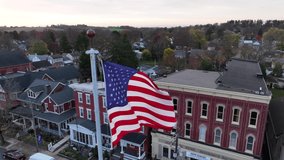 American flag waves in breeze. Slow motion aerial establishing shot of small town in USA. Patriotic Proud to be an American theme. - Powered by Shutterstock - Get 15% off with code: PIKWIZARD15
