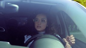 Beautiful happy woman driving a vehicle on sunny day. Female driver beginner practicing driving after getting licence. Caucasian woman with curly hair learning to drive a car. Close up - Powered by Shutterstock - Get 15% off with code: PIKWIZARD15