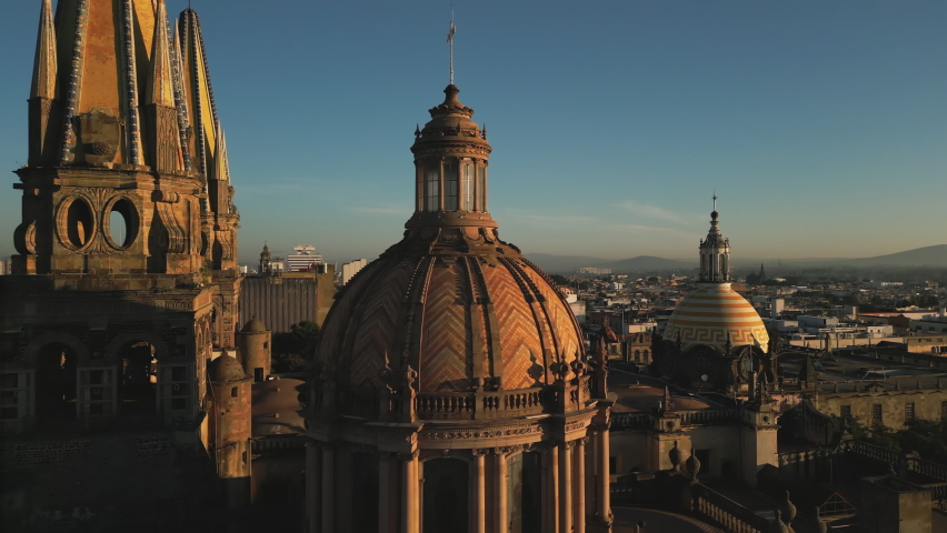 Beautiful sunset above the square with gothic spires towering the city. Drone footage of Plaza Guadalajara with cinematic views on the Cathedral. High quality 4k footage Royalty-Free Stock Footage #1096740347