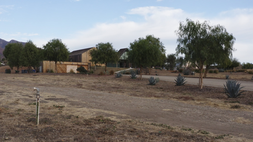 Approaching aerial of an off roader jeep reaching luxury countryside cottage in the beautiful valley.