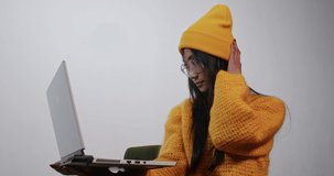 joyful asian woman uses laptop and phone for work and video communication.