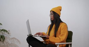 joyful asian woman uses laptop and phone for work and video communication.