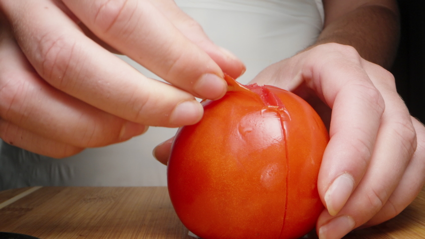 A girl peels a tomato from the peel, close-up. Royalty-Free Stock Footage #1096757273