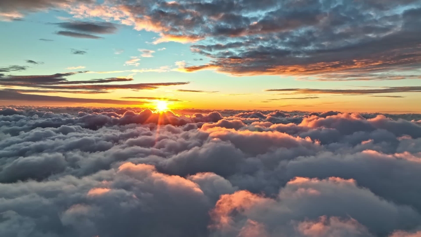 Magnificent sunrise on dense clouds. Aerial view of sun rises from behind the clouds starting a new day. Rising sun illuminates clouds in bright pink color. Great sunrise at Madeira island Royalty-Free Stock Footage #1096758353
