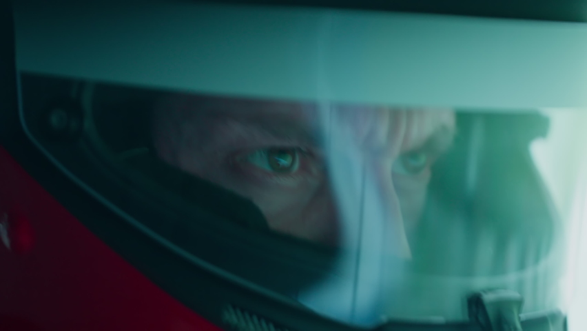 ECU Portrait of sports car driver in protective helmet racing on a speedway. Fast speed, motorsport. Daytime shot Royalty-Free Stock Footage #1096761637
