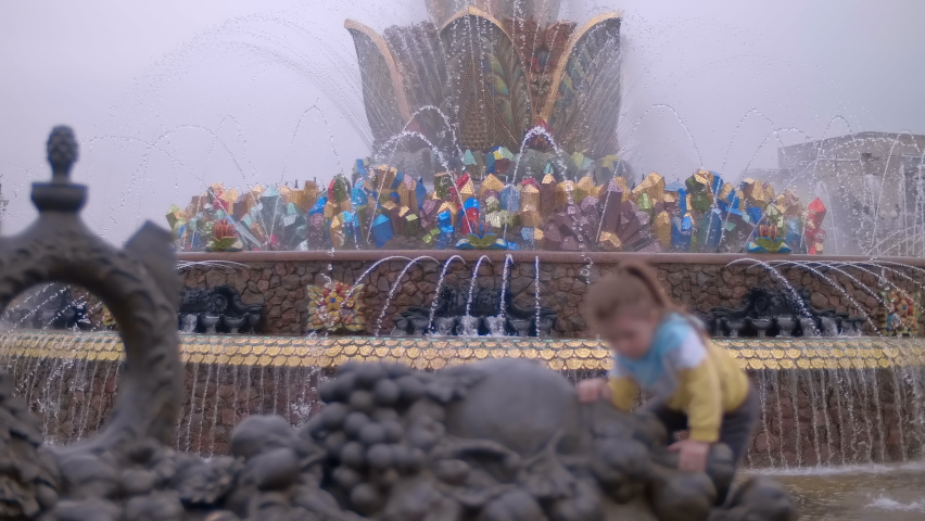 Fountain "Stone Flower" at VDNH is a famous historical landmark - a bowl in the form of a flower blooming among gems. Defocused children playing in the foreground