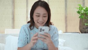 Cute Asian woman shows a feeling of excitement and joy after seeing something on the phone screen.
