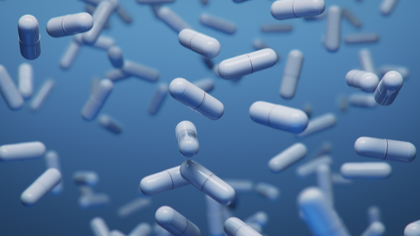 Slow Motion Shot of Falling White Capsules on Blue Background.