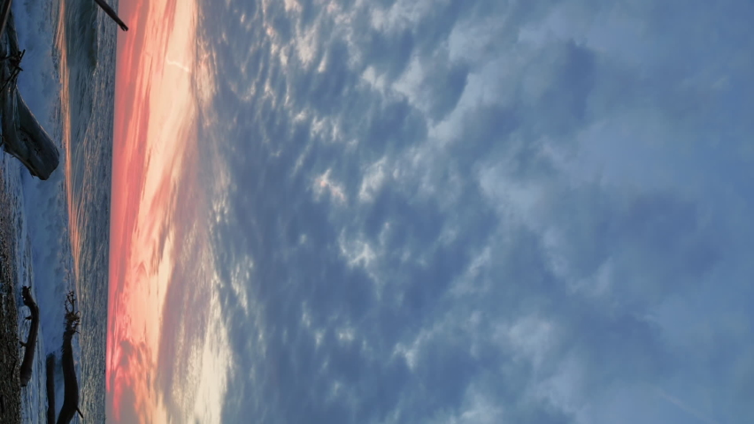 Evening idyllic landscape with calm sea surf and cloudy sky. Pink sunset