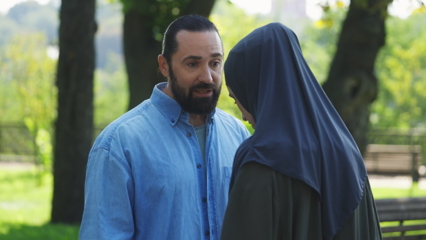 Rude Muslim man shouting at unhappy wife in park, domestic violence problem