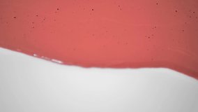 Brown pearlescent thick glossy liquid flows down slowly in a wave over a white background.Artistic paint advertisement.Advertising concept for face decorative cosmetics.