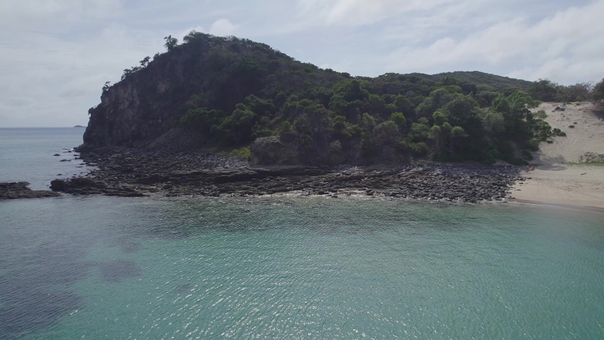 Rocky And White Sand Beach Of Butterfish Bay With Sailboat In Great Keppel Island, Capricorn Coast, Queensland, Australia. Aerial Pullback
