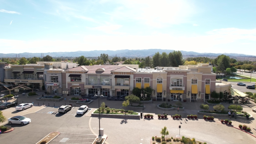 Bridgeport Marketplace In Santa Clarita. Aerial Dolly Left Across Front Entrance with parked cars