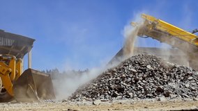 slow motion footage of a bulldozer scooping up the gravel from a pile of construction debris under a conveyor belt - Powered by Shutterstock - Get 15% off with code: PIKWIZARD15
